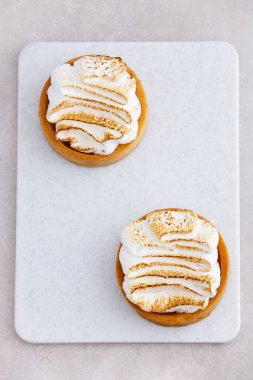 Krem şantili tart beyaz mermer mutfak masasına yakın.