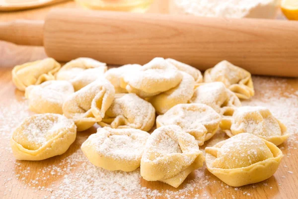 flouring tortellini ready to cook on wood