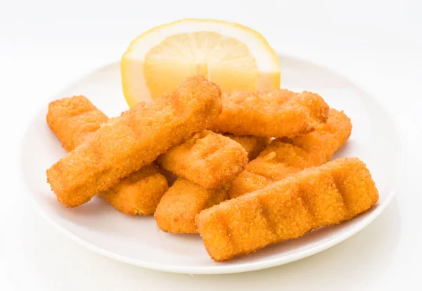 Breaded fish sticks with cut lemon on white plate
