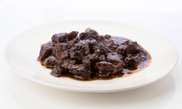 stewed dish with squid in its ink, on white