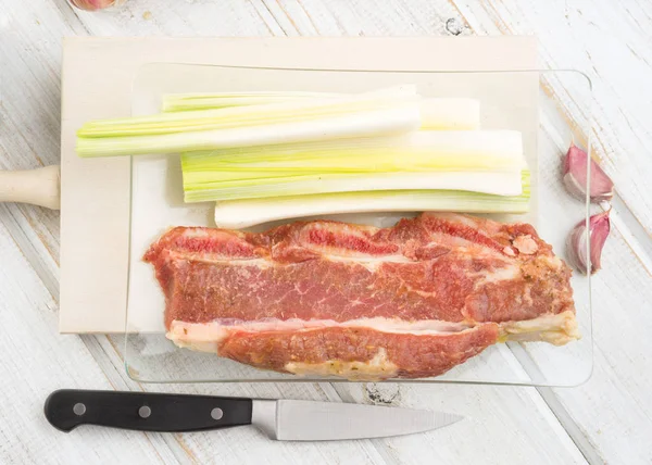 aerial take of raw meat vegetables and eggs, on white wood