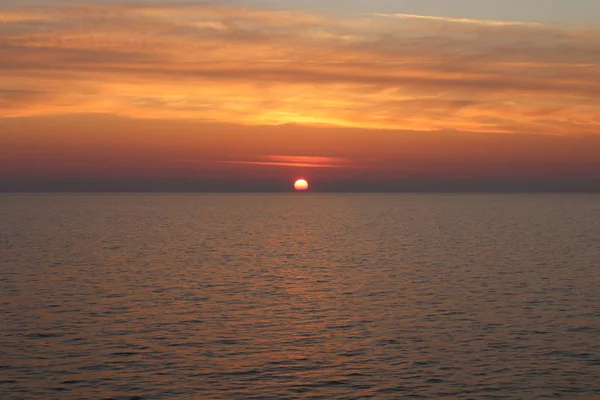 evocative image of sunrise over the sea with the sun rising over the horizon