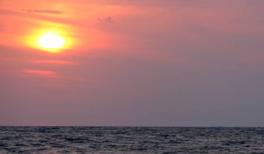 deniz üzerinde gün batımı çağrıştıran görüntü