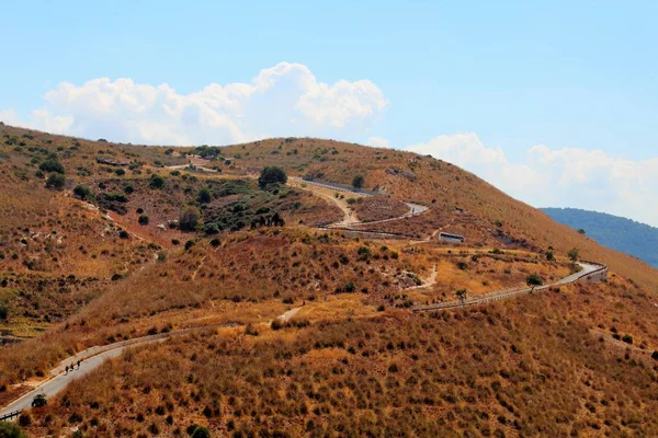 Sicilya'da kurak bir tepeüzerinde yokuş yukarı yol çağrıştıran görüntü