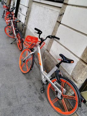 Milano, İtalya - 16 Şubat 2019: Kaldırımda park etmiş Mobike bisiklet paylaşımını çağrıştıran bir hayal