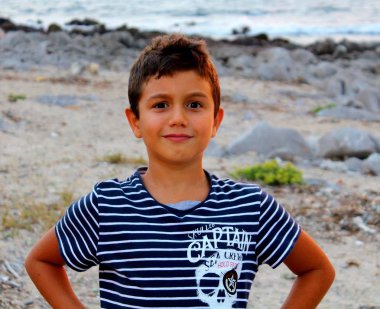 çizgili gömlek li çocuğun gün batımında banksea oynayan mutlu bir şekilde çağrıştıran görüntüsü, yakın