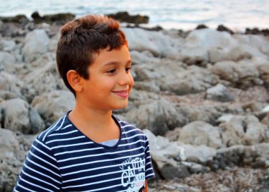 çizgili gömlek li çocuğun gün batımında banksea oynayan mutlu bir şekilde çağrıştıran görüntüsü, yakın