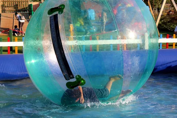 プールの水の上に浮かぶ膨脹可能なボールの中で楽しんでいる子供の感動的なイメージ — ストック写真