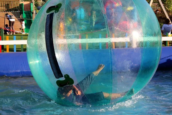 プールの水の上に浮かぶ膨脹可能なボールの中で楽しんでいる子供の感動的なイメージ — ストック写真