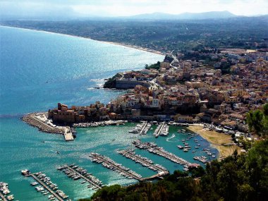 Sicilya 'daki Castellammare del Golfo limanının şatosu ve arka planında plajı olan panoramik bir görüntüsü.