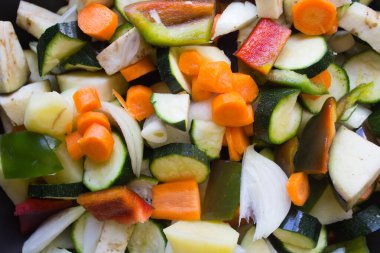 Kabaklar, havuçlar, biberler, soğanlar, patlıcanlar ve sarımsak kesimi vejetaryen kuskus için hazırlanıyor.