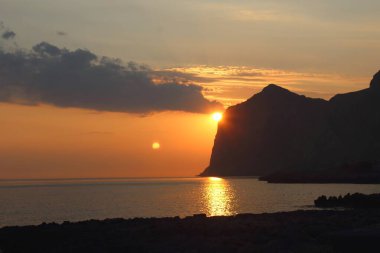 Güneşin ufukta doğuşuyla birlikte denizin üstünde güneşin doğuşunun canlandırıcı görüntüsü.