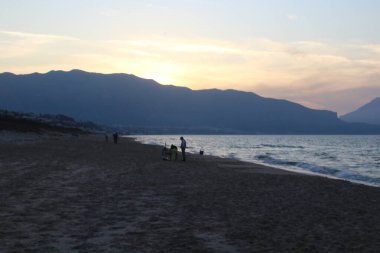 Güneş batarken ön taraftaki denizle birlikte