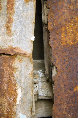 Eski ahşap kirişlere çivilenmiş paslı metal levhaların canlandırıcı görüntüsü.