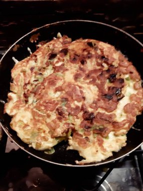 Pişirdikten sonra yumurta, tuz, biber ve soğandan oluşan ev yapımı omletin canlandırıcı görüntüsü.