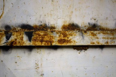 Beyaz demir kapının paslı kısımlarının detaylarını anımsatan yakın plan görüntüsü.