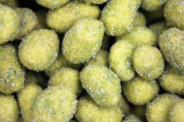 Wasabi ile kaplanmış fındık fıstığının parmak yemeğe hazır olduğunu anımsatan yakın plan görüntüsü.