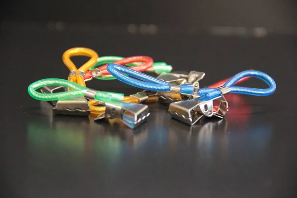 colorful small metal clips on a black background