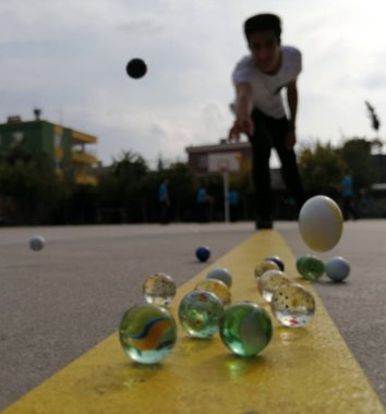 Batan güneşin ışığında kaldırımda misketler..