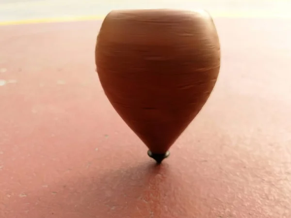 wooden spinning top while spinning on the ground