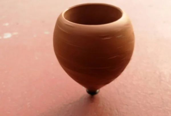 wooden spinning top while spinning on the ground