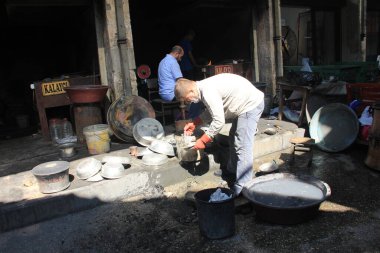 Bakır maddeyi geleneksel Türk tenekesiyle kaplayan adam