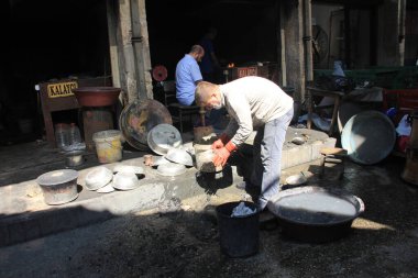 Bakır maddeyi geleneksel Türk tenekesiyle kaplayan adam