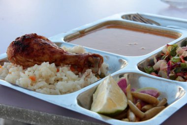 Tavuk, pirinç ve salata servis tabağında.