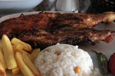 Tavuk, pirinç ve salata servis tabağında.