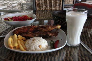 Tavuk, pirinç ve salata servis tabağında.