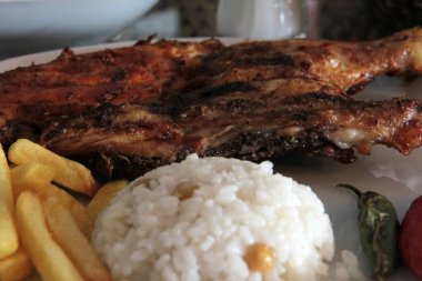 Tavuk, pirinç ve salata servis tabağında.