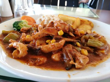 Tavuk, pirinç ve salata servis tabağında.