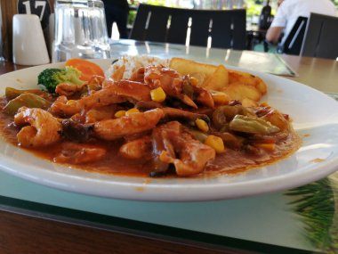 Tavuk, pirinç ve salata servis tabağında.