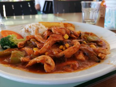 Tavuk, pirinç ve salata servis tabağında.