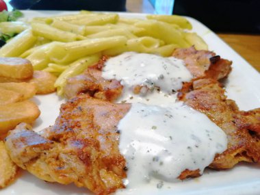 Tavuk, pirinç ve salata servis tabağında.