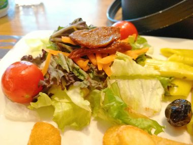 Tavuk, pirinç ve salata servis tabağında.