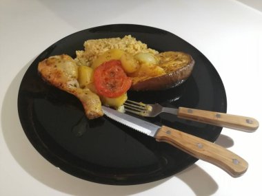 Tavuk, pirinç ve salata servis tabağında.