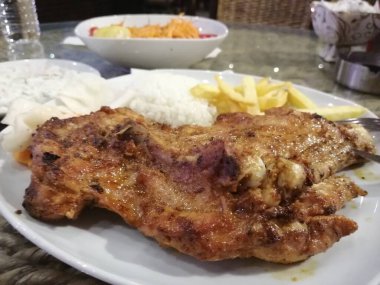 Tavuk, pirinç ve salata servis tabağında.