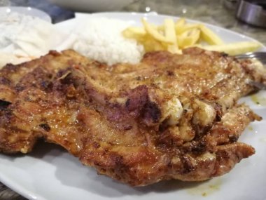 Tavuk, pirinç ve salata servis tabağında.