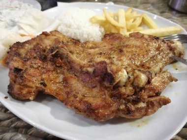 Tavuk, pirinç ve salata servis tabağında.