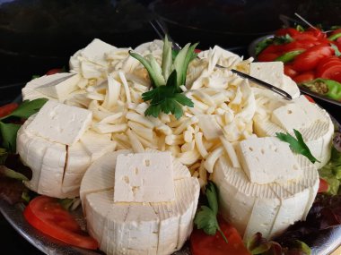 Masada çeşitli peynirlerle servis edilen peynir tabağı.