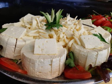 Masada çeşitli peynirlerle servis edilen peynir tabağı.