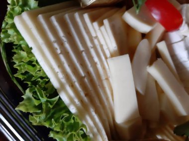 Masada çeşitli peynirlerle servis edilen peynir tabağı.