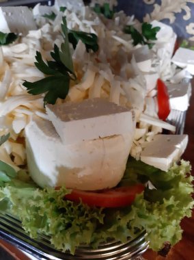 Masada çeşitli peynirlerle servis edilen peynir tabağı.