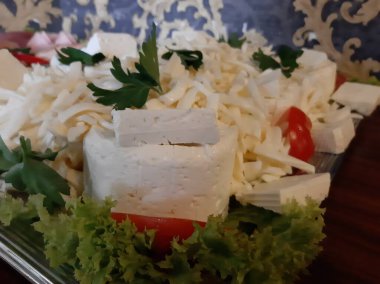 Masada çeşitli peynirlerle servis edilen peynir tabağı.