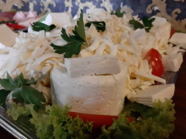 Masada çeşitli peynirlerle servis edilen peynir tabağı.