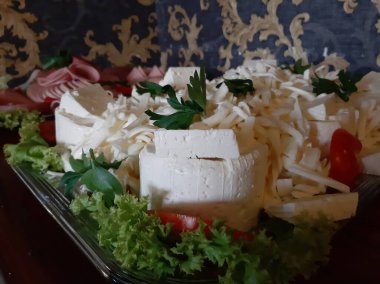 Masada çeşitli peynirlerle servis edilen peynir tabağı.