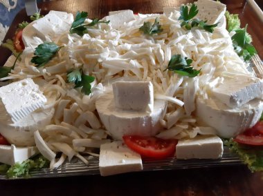 Masada çeşitli peynirlerle servis edilen peynir tabağı.