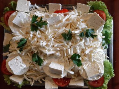 Masada çeşitli peynirlerle servis edilen peynir tabağı.