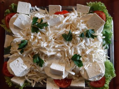 Masada çeşitli peynirlerle servis edilen peynir tabağı.